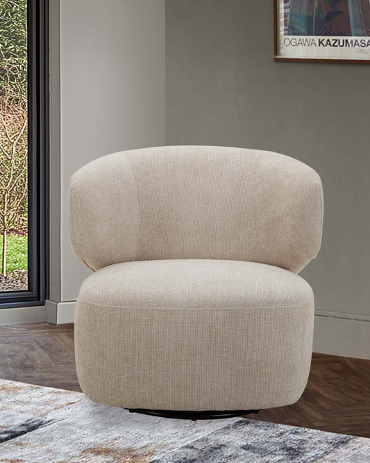 A contemporary, plush beige swivel chair with a rounded backrest and a sleek black base, set against a minimalist backdrop.