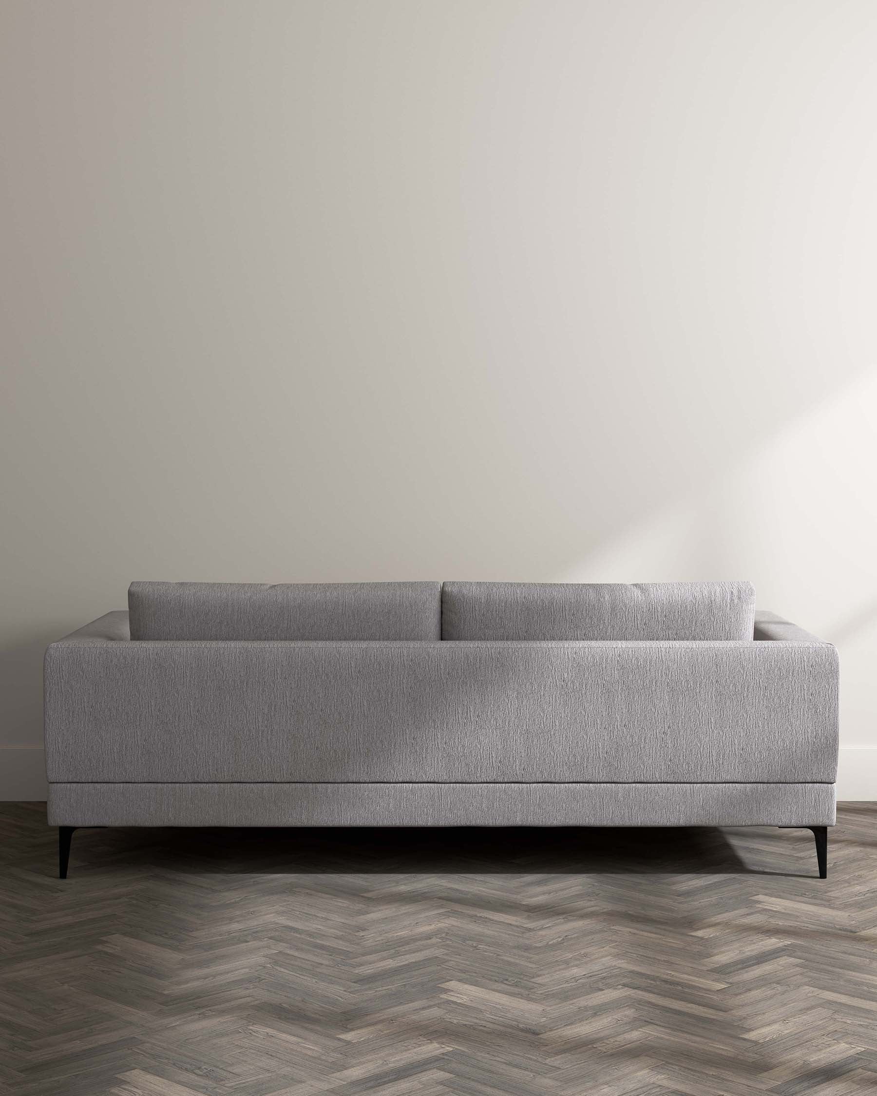 Elegant modern grey fabric sofa with a simplistic streamlined design, featuring low-profile arms, a straight backrest, and angled metal legs for a touch of contemporary chic.