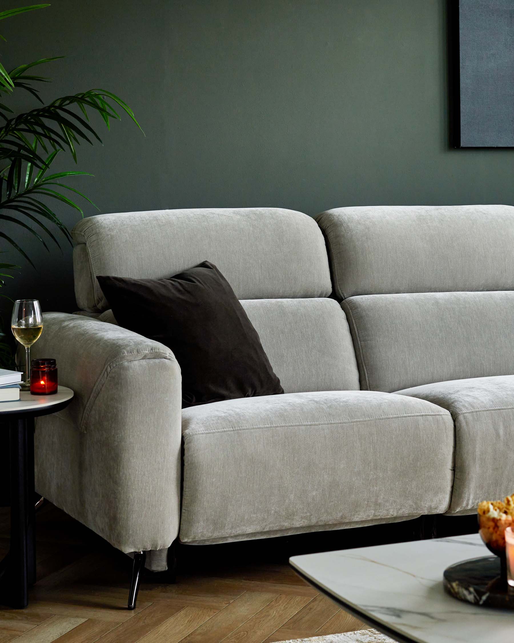 A soft gray sectional sofa with a dark throw pillow, paired with a circular coffee table, creating a cozy living space.