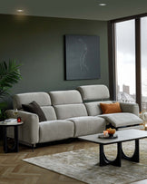 Modern gray sectional sofa, accented with a brown pillow, paired with a sleek coffee table featuring curved black legs.