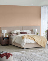 A plush bed with a soft headboard, nightstands, stylish lamps, a cozy throw blanket, and a textured rug.