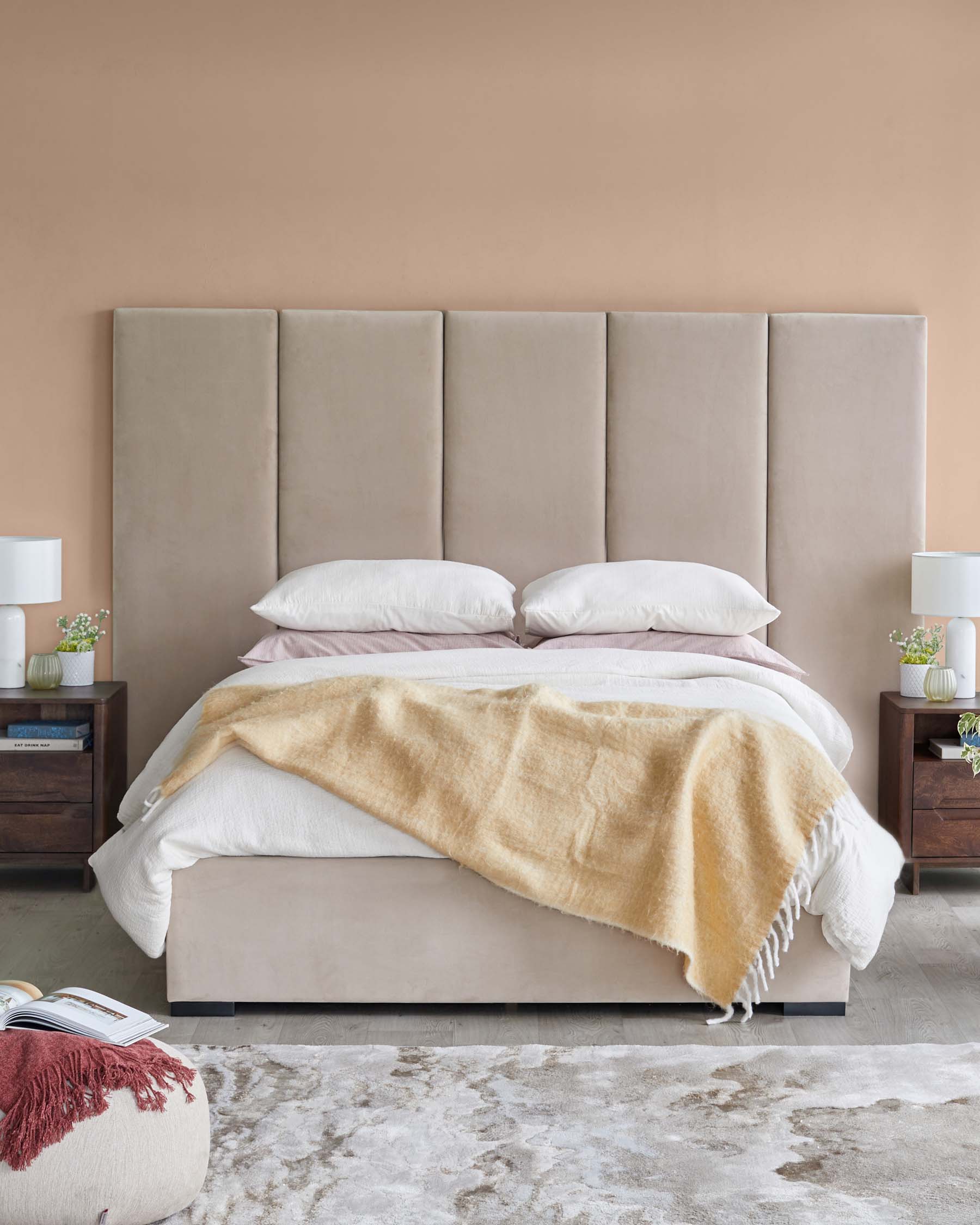 Elegant upholstered bed with a tall headboard, soft bedding, wooden nightstands, and cozy textiles on a stylish rug.