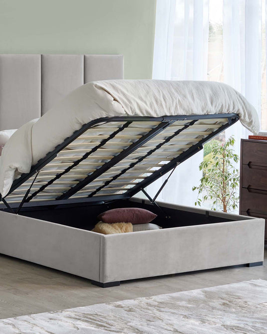 A stylish upholstered bed with an elevated mattress revealing spacious under-frame storage, enhanced by a cozy, soft bedding aesthetic.