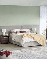 Modern bedroom set featuring a plush bed with layered linens, nightstands, lamps, and a cozy throw blanket.