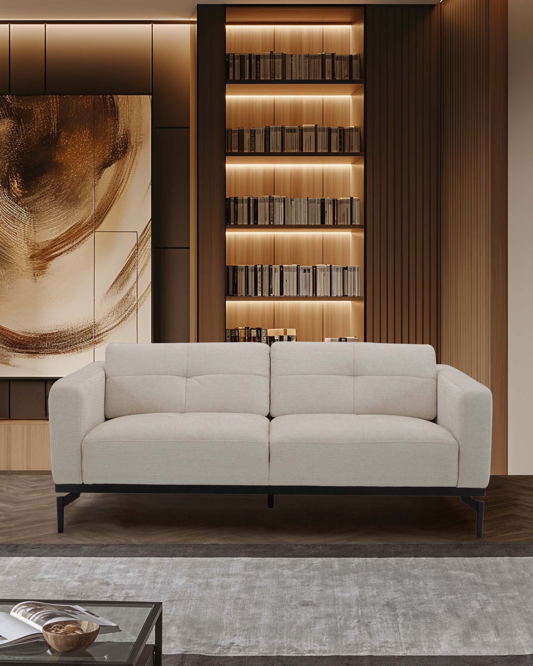 A modern beige sofa with clean lines, black legs, positioned against a stylish backdrop of wood shelving and soft lighting.