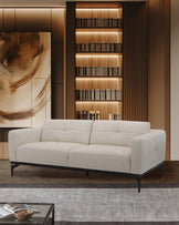 Light beige modern sofa with tufted cushions, complemented by a stylish black frame and surrounded by elegant wooden shelving.