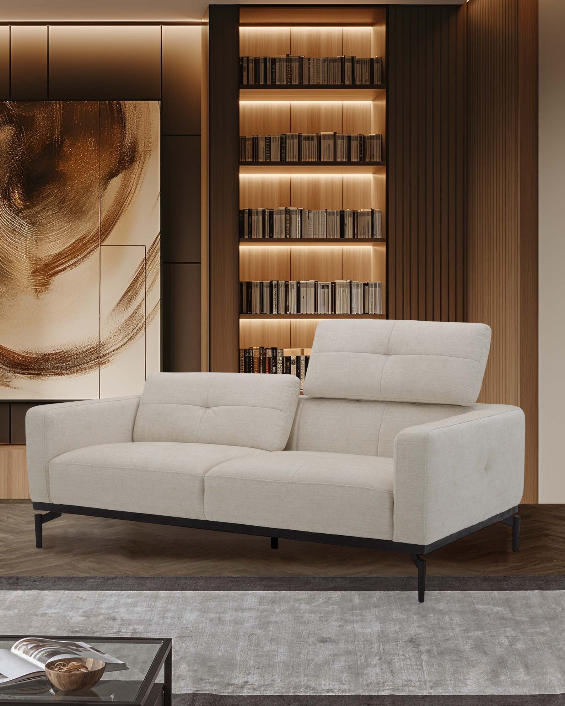 A modern cream-colored sofa with sleek lines, tufted surfaces, and black metal legs, paired with a stylish rug and bookshelves.