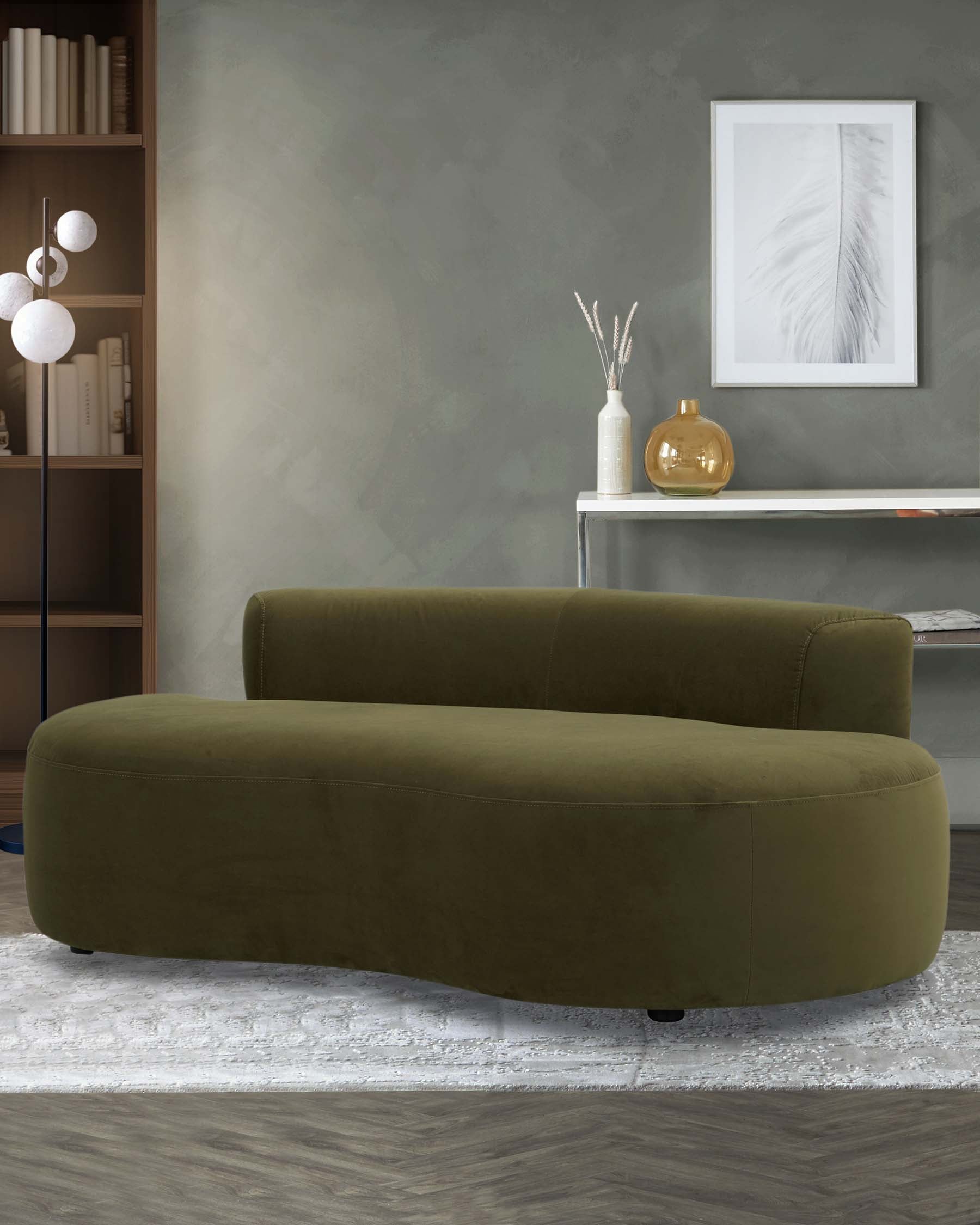 A modern olive green curved sofa on a textured rug, complemented by minimalist decor and light wooden shelving.