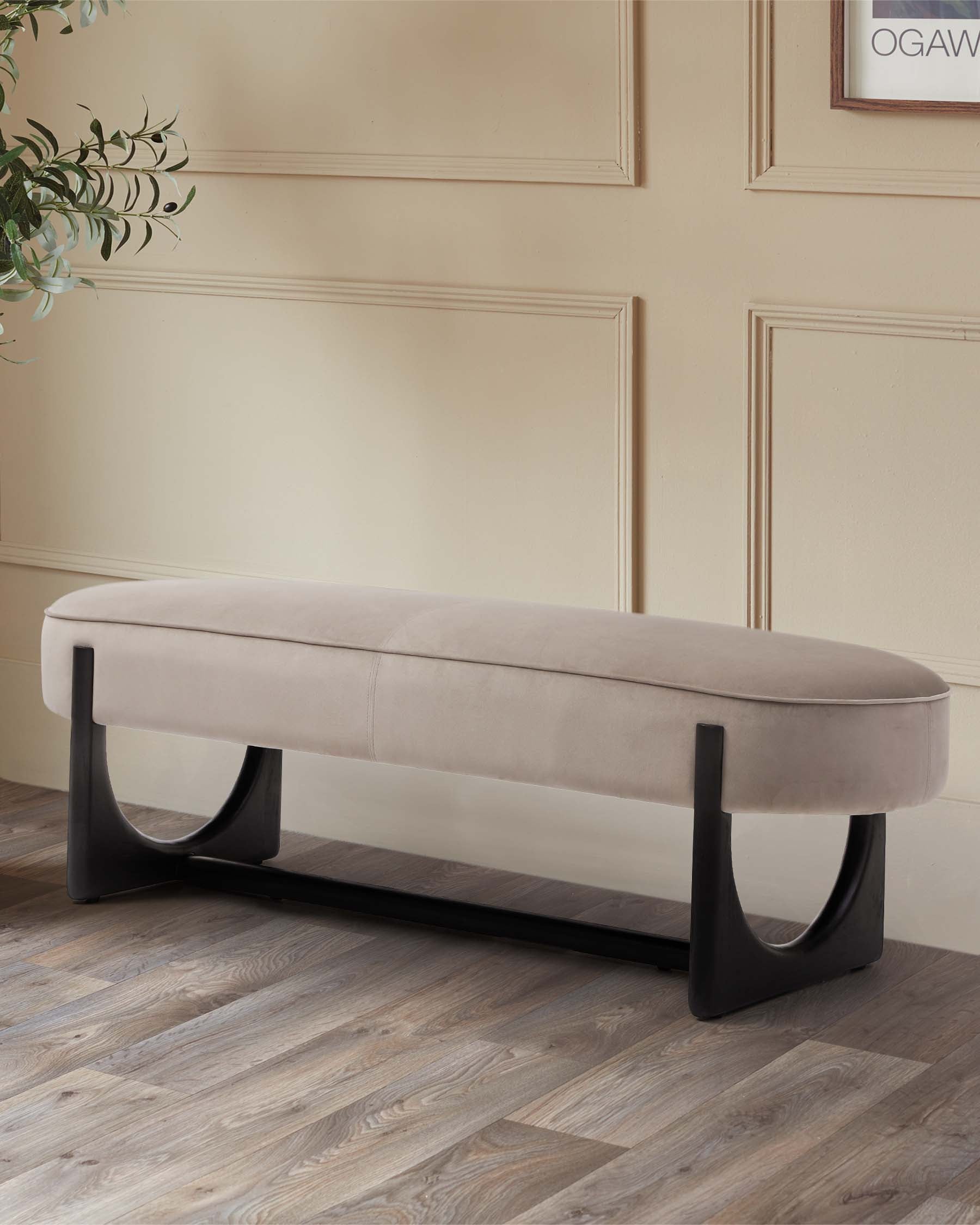 A sleek, beige upholstered bench with a modern black base, perfect for stylish seating in any room.