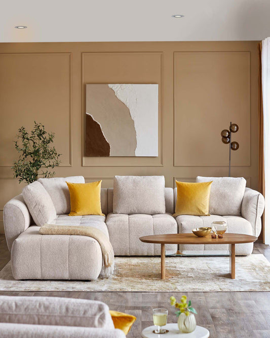 Cozy beige sectional sofa with yellow cushions, a wooden coffee table, and a soft throw, set against a neutral-toned wall.