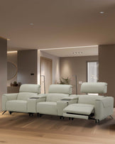 A modern, light beige reclining sectional sofa with comfortable cushions and built-in armrests, ideal for relaxation.