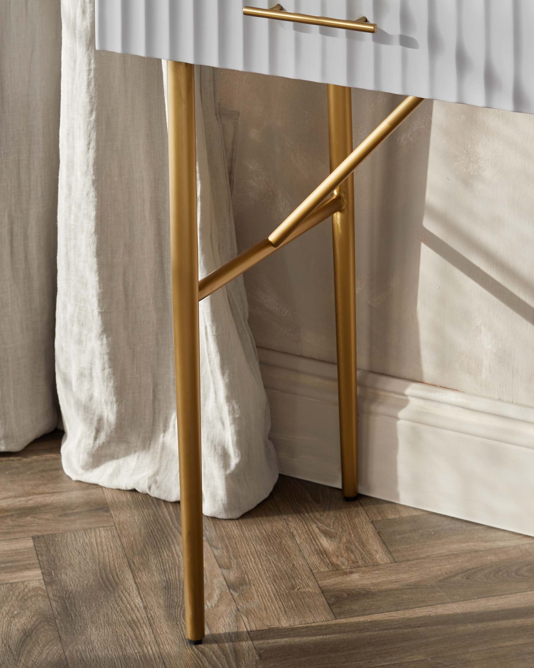 Elegant contemporary console table with a sleek white marble top and slender matte gold metal legs, accented by a striking geometric frame and a horizontal gold bar handle.