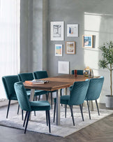 Modern dining room furniture featuring a rectangular walnut-finish table and six teal upholstered chairs with channel tufting and tapered metal legs. The set is placed on a textured white area rug.