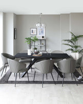 Modern dining room featuring a sleek, black rectangular table with a unique angular leg design, complemented by six contemporary grey upholstered chairs with black metal legs. A minimalist grey shelving unit decorates the background.