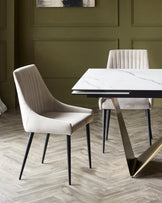 Modern dining set featuring a sleek marble-top table with a stylish metal base and two upholstered chairs with ribbed details.