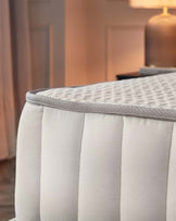 Elegant cream mattress with quilted texture and subtle trim, showcasing luxury and comfort in a refined setting.