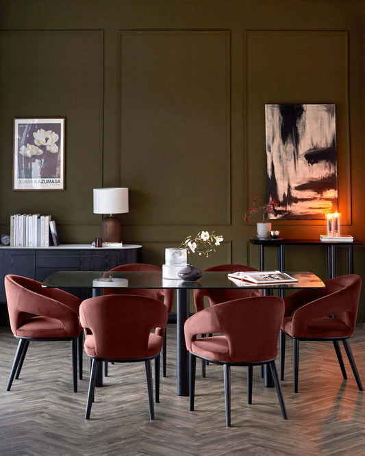 Elegant dining set featuring a glass tabletop, four rust-colored upholstered chairs, and stylish accent pieces on a dark wood floor.