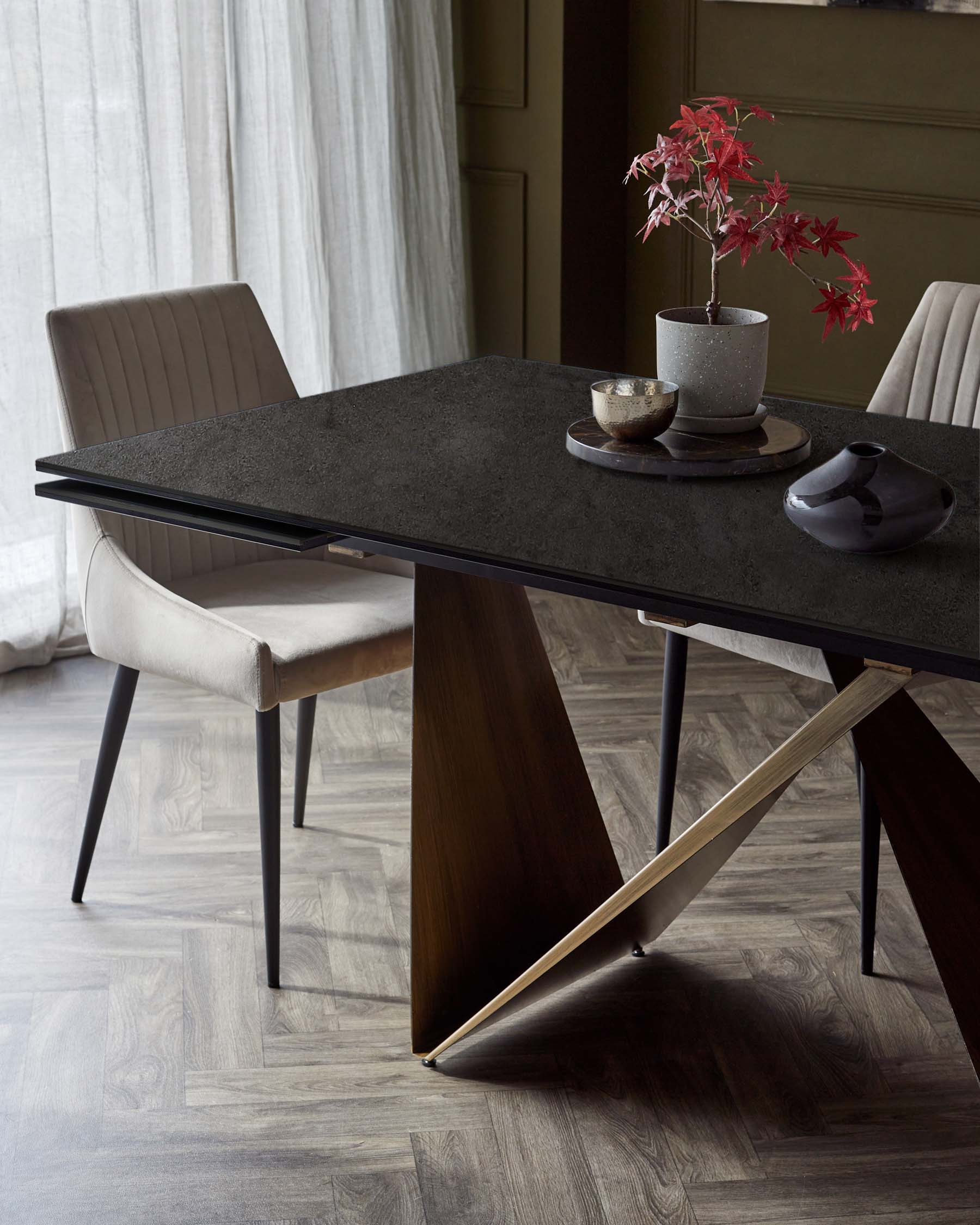 A sleek, modern dining table with an intricate base and two stylish cream chairs, adorned with decorative elements.