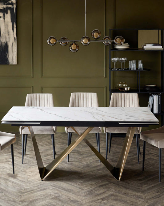 A modern dining table with a marble top and gold legs, accompanied by plush velvet chairs in a neutral tone.