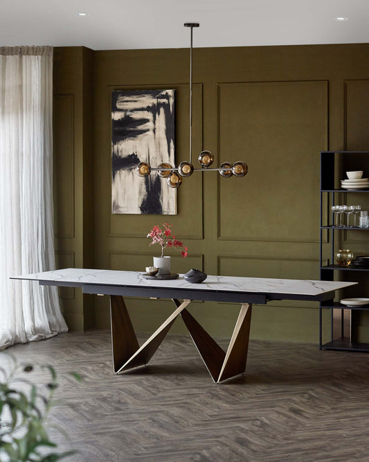 Modern dining table with a marble top and angular wooden legs, complemented by a unique pendant light and minimalist shelving unit.