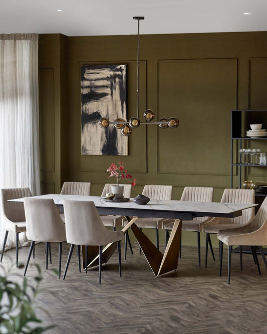 Elegant dining set with a marble-top table, stylish beige chairs, and a modern chandelier in a green-paneled room.