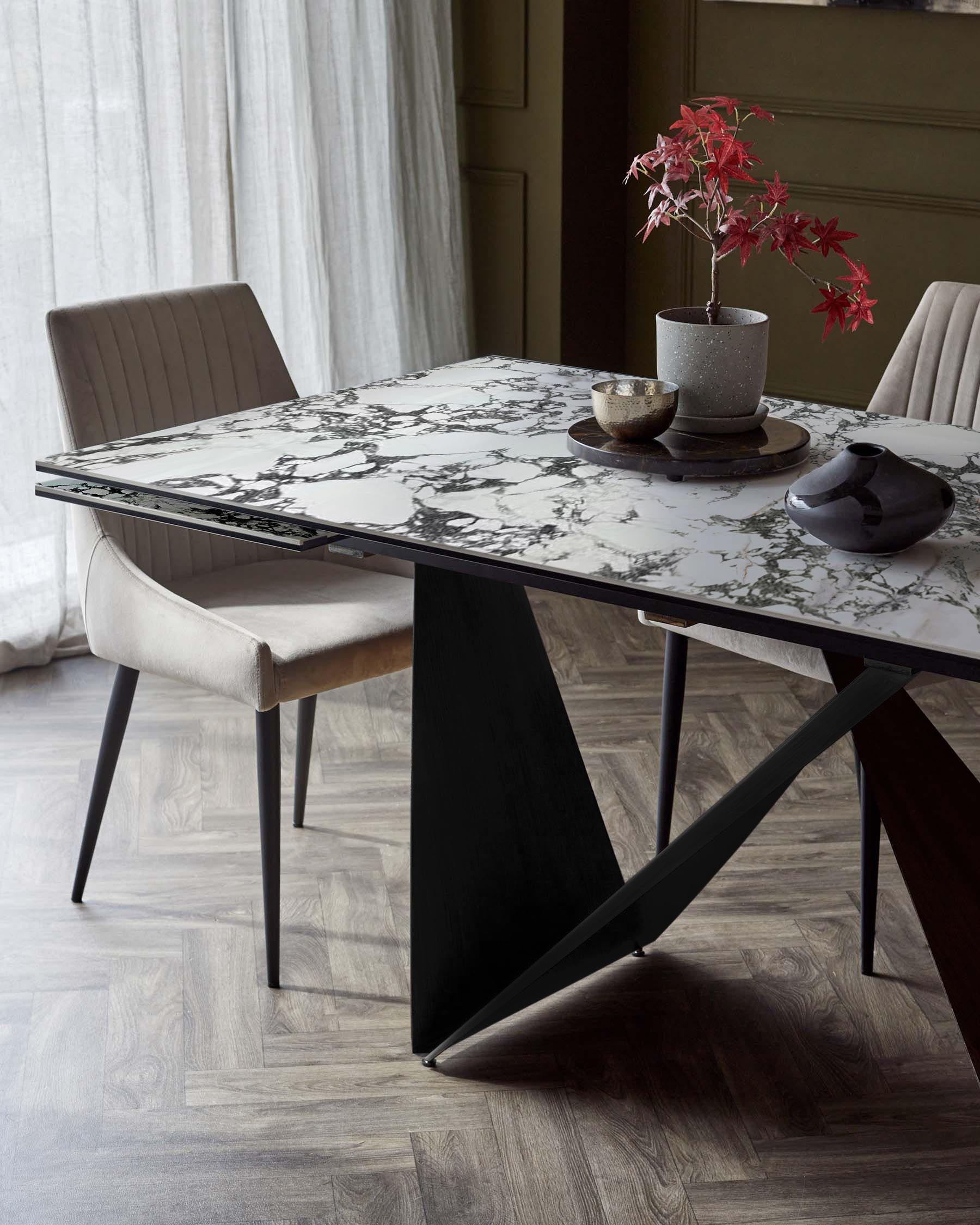 Modern dining table with a marble top and sleek black base, paired with a plush, upholstered chair. Elegant and contemporary.