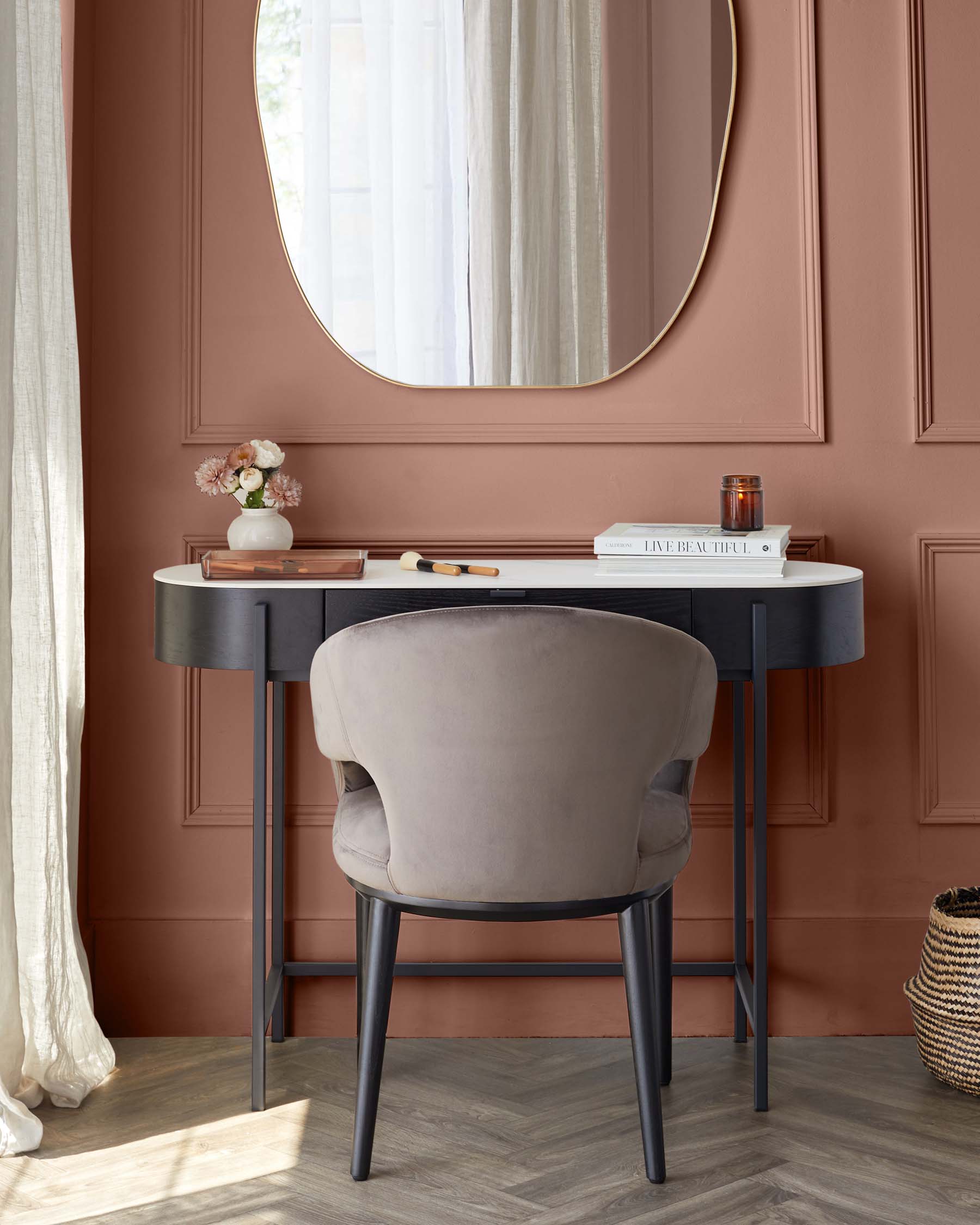 Elegant half-moon console table with a smooth black finish and two slender metal legs paired with a contemporary, taupe upholstered chair featuring a curved backrest and black wooden legs.