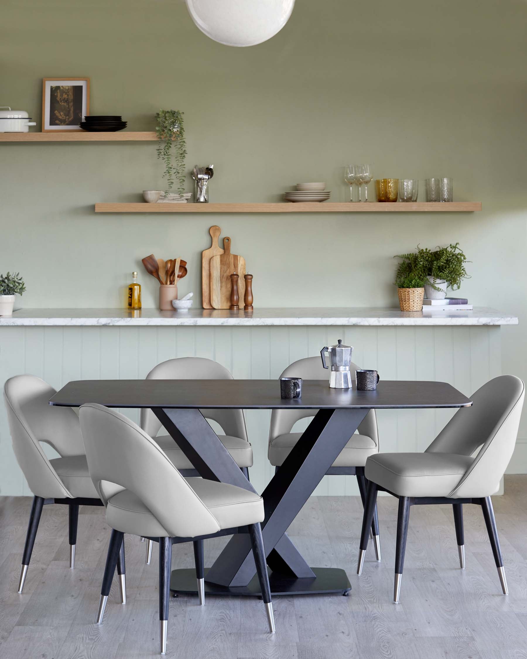 Contemporary dining room with a rectangular black table with a unique X-shaped leg design, paired with four elegant light beige upholstered chairs with black legs tipped with metallic accents. A seamless blend of modern design and comfort.