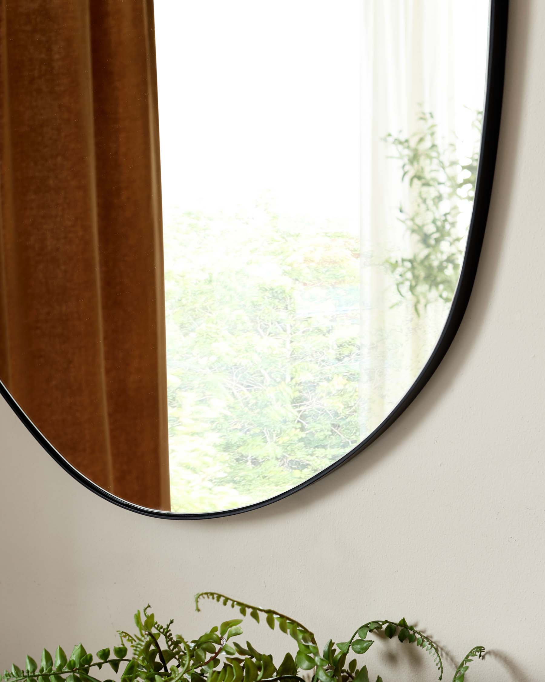 Minimalist round wall mirror with a slim black frame.