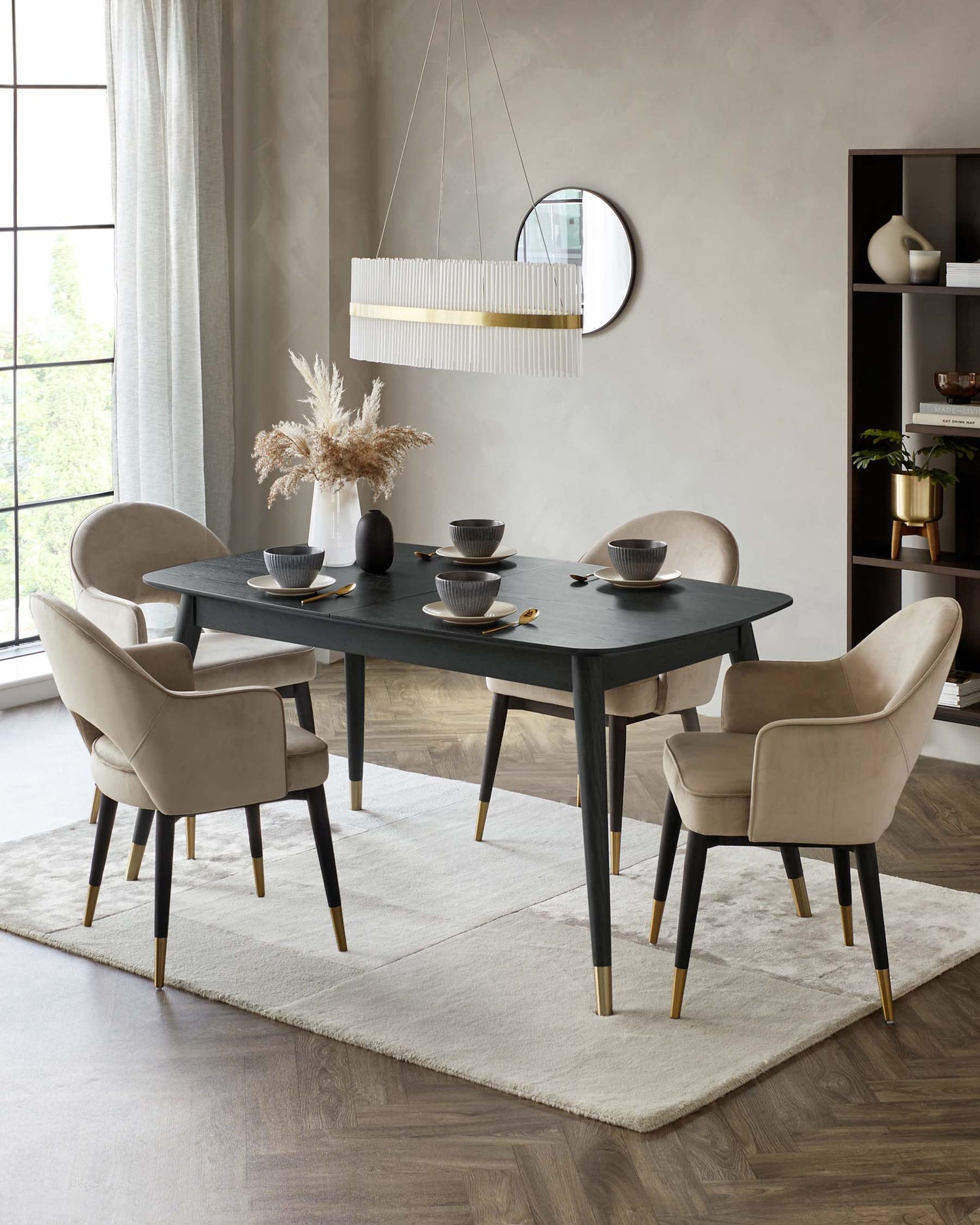 A sleek black dining table with four stylish beige chairs, adorned with elegant gold accents, set against a soft rug.