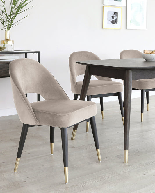 Stylish dining set featuring elegant velvet chairs with gold-tipped legs and a sleek dark wooden table.