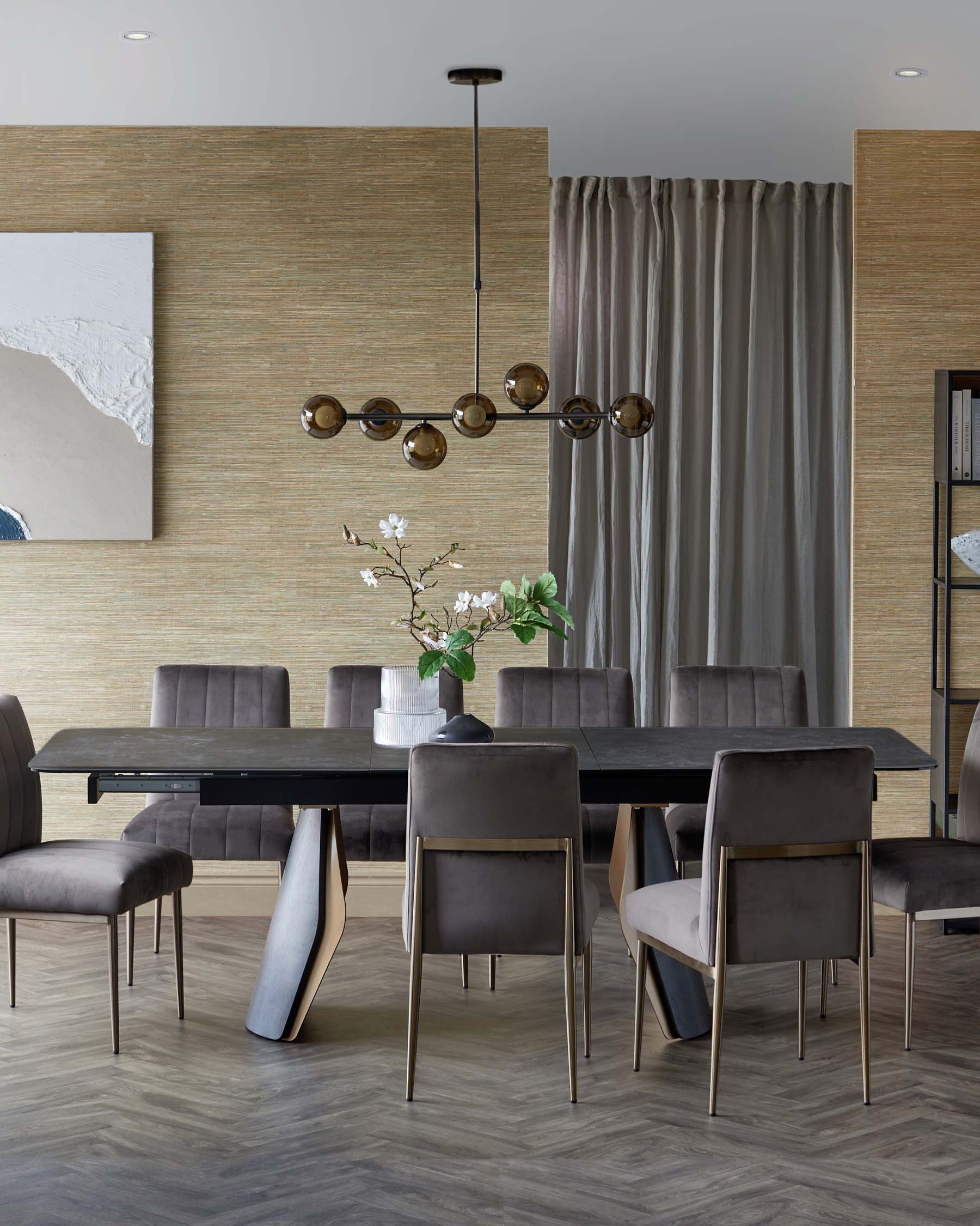 Elegant dining set featuring a modern black table and plush gray chairs, illuminated by a stylish pendant light.