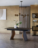 A modern dining table with a sleek black surface and sculptural wooden legs, paired with a stylish pendant light above.