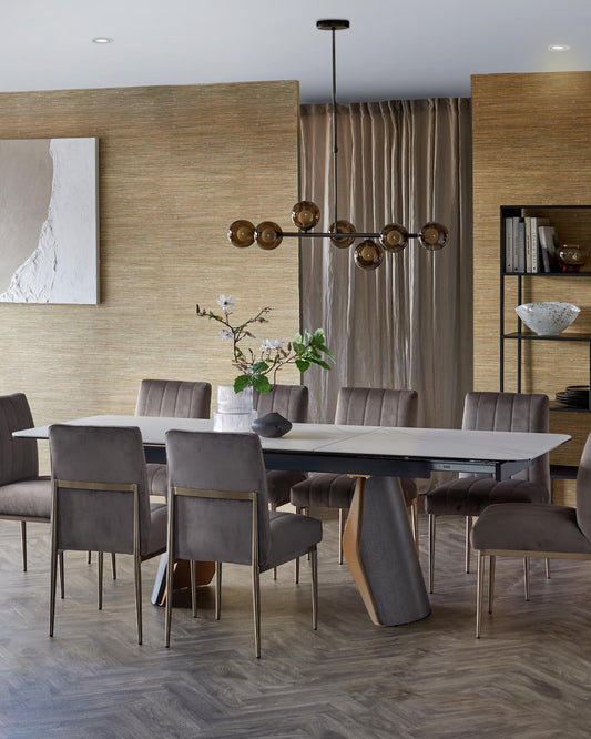 Modern dining table with sleek design, paired with upholstered gray chairs and a stylish pendant light above.