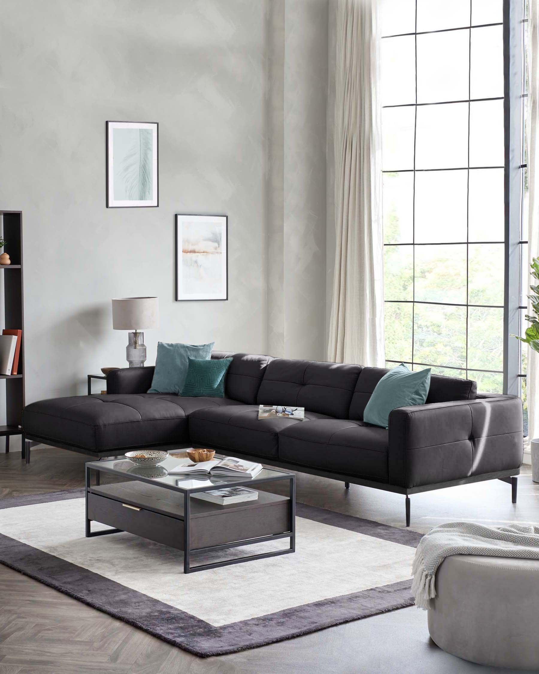 Modern black sofa with teal cushions, glass-top coffee table, textured rug, and stylish accent pieces in a bright, airy space.