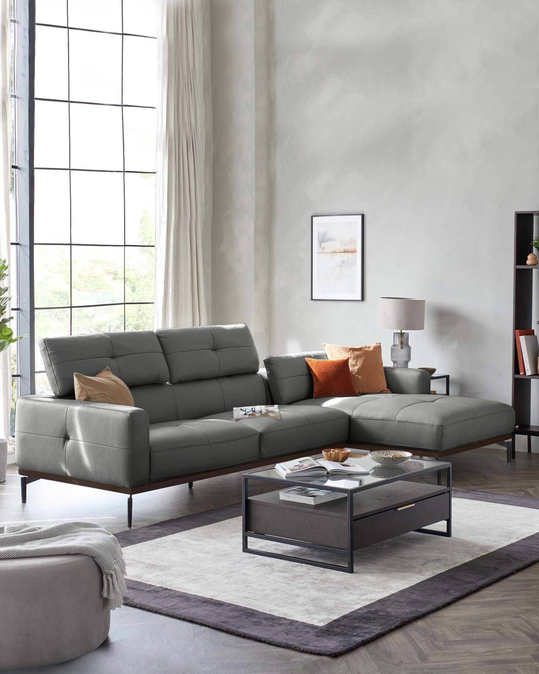 Modern gray leather sectional sofa with plush pillows, sleek glass-top coffee table, and stylish area rug in a bright room.