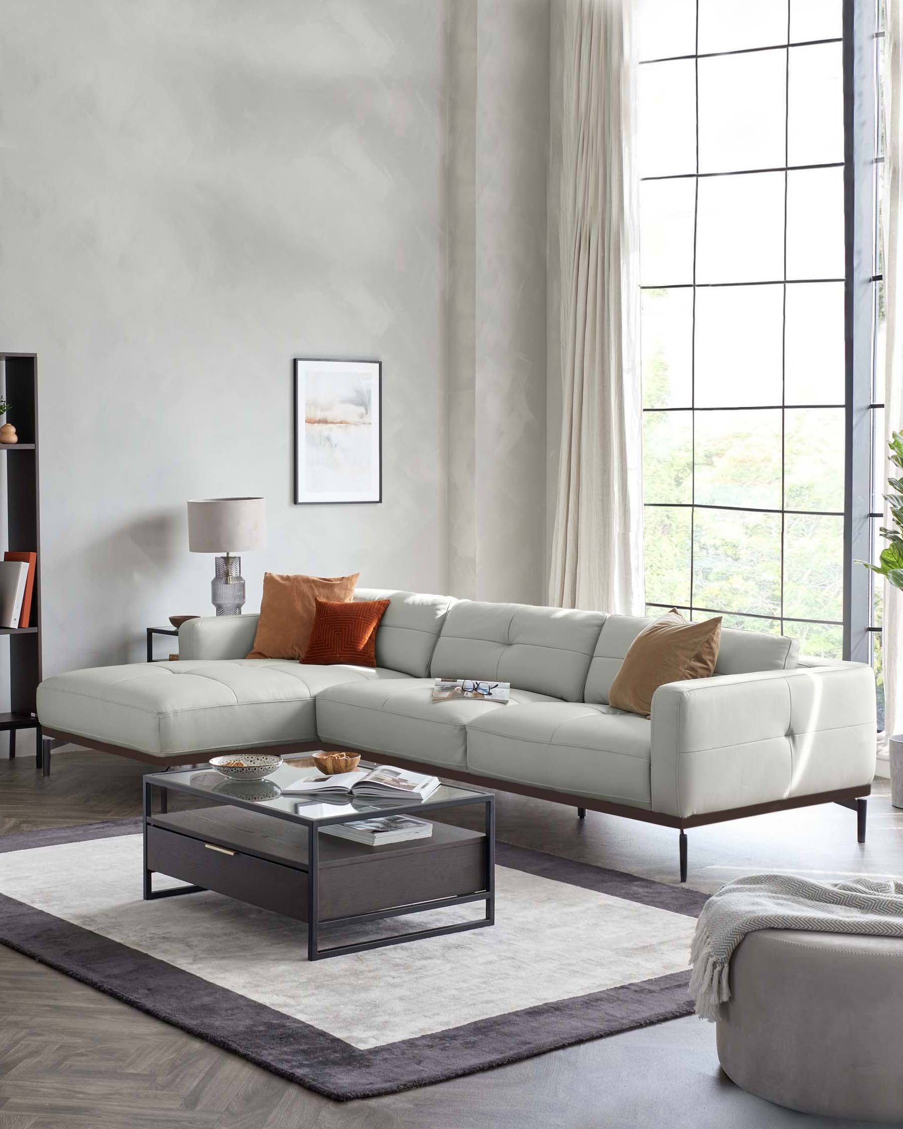 Elegant modern living room featuring a large, L-shaped, light cream upholstered sectional sofa with clean lines and a minimalist aesthetic, centred around a contemporary rectangular coffee table with a glass top and dark wooden frame, complemented by a soft grey area rug underneath. To the left, a sleek dark wooden sideboard with decor accentuates the space.