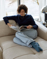 A modern beige fabric sofa with a comfortable and casual design, featuring deep seating cushions and a relaxed silhouette.