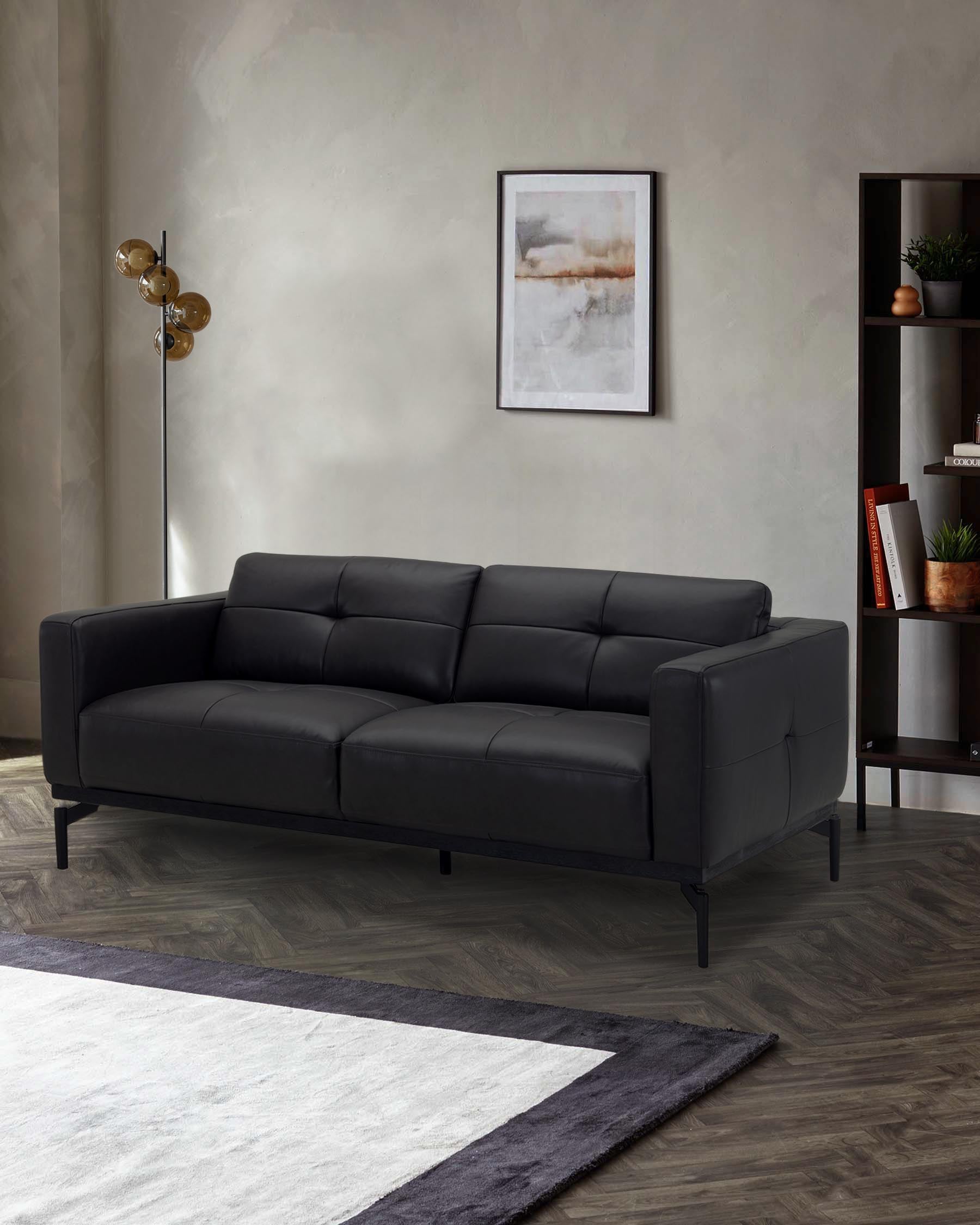 A modern black leather sofa with a sleek design, paired with an artistic wall print and a tall, stylish floor lamp.