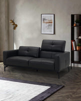 Modern black leather sofa with sleek lines, accompanying floor lamp, and stylish bookshelf in a contemporary setting.