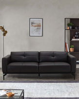 Modern black leather sofa with sleek lines, a minimalistic design, complemented by a stylish bookshelf and floor lamp.