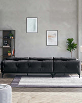 A sleek black leather sofa with tufted design, accompanied by a geometric area rug, shelving unit, and decorative plant.