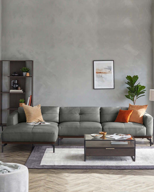 Stylish gray leather sectional sofa with accent pillows, modern coffee table, and plant, paired with minimalist decor.