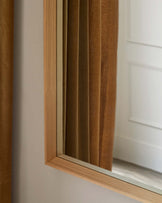 No furniture is visible in the image, only a close-up view of a curtain partially covering a window frame and a glimpse of a white door.