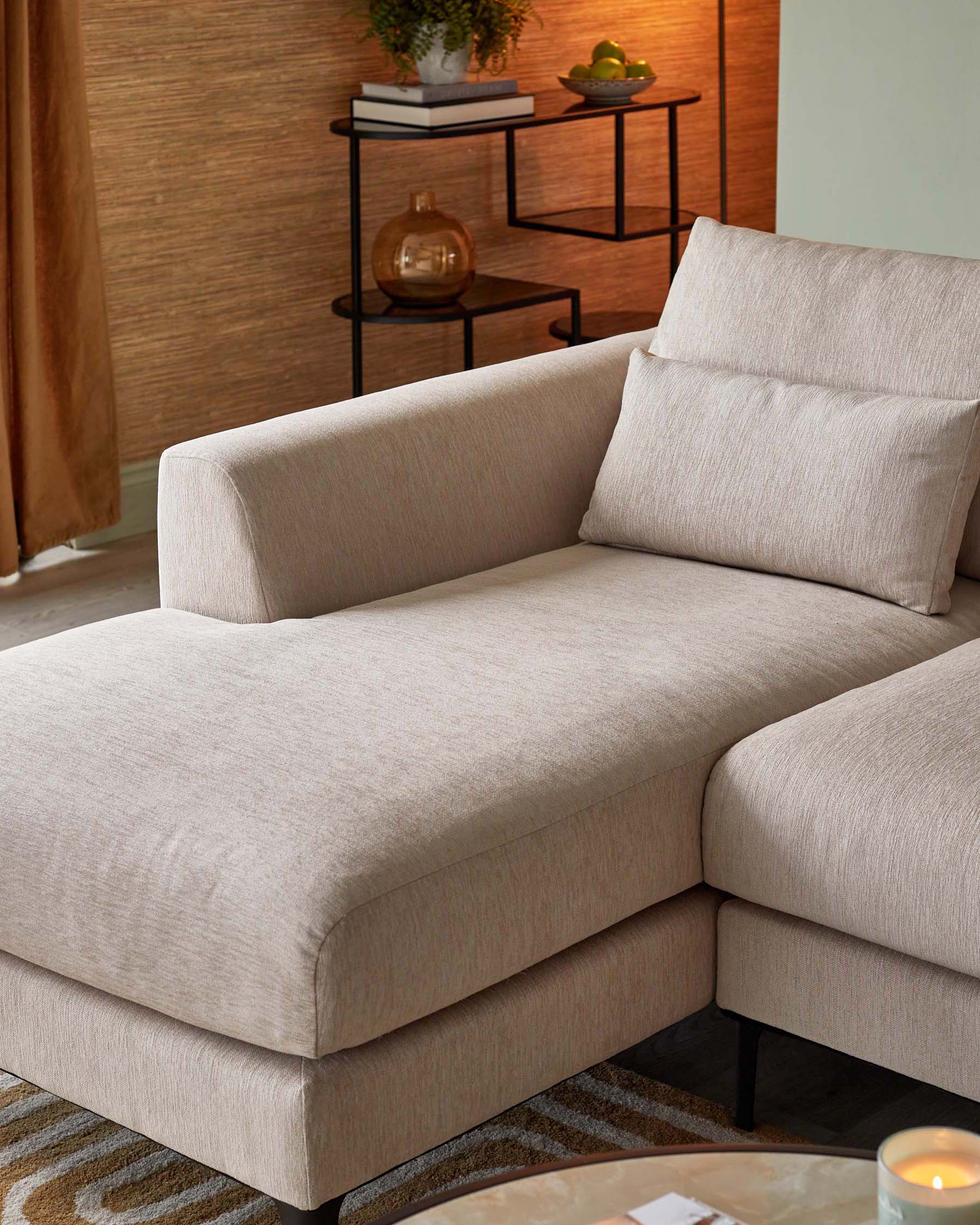 Contemporary beige fabric sectional sofa with a chaise, clean lines, and minimalistic design, paired with a small multi-level black metal frame side table with wood finish shelves, accessorized with plants and decorative items.