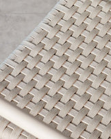 Close-up view of a tightly woven, neutral-toned textile fabric with a herringbone pattern, possibly part of a modern piece of furniture.