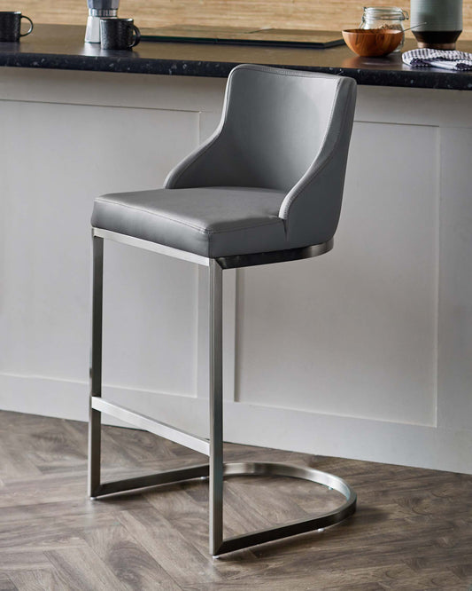 Sleek grey upholstered barstool with a minimalist metal frame, designed for modern kitchen spaces.