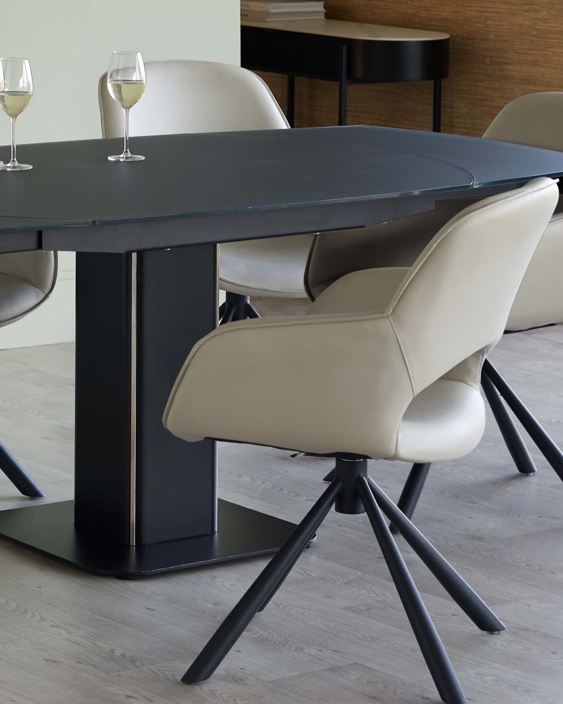 Modern dining table with a sleek glass top and a black base, paired with stylish beige swivel chairs.