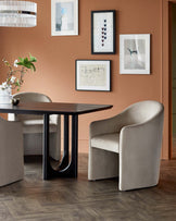 Elegant dining table with a dark top and modern black base, paired with curved, light-colored upholstered chairs.