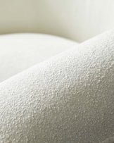 Textured white upholstery showcasing a soft, plush surface with a rounded design, ideal for modern interior spaces.